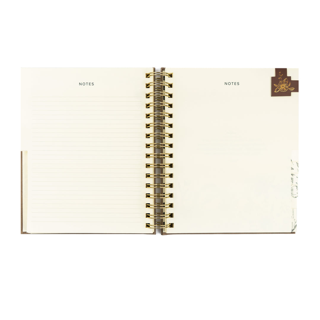 Open notebook with 'NOTES' label on each page, gold spiral binding, and brand logo on a white background.