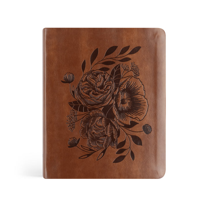 Brown leather notebook with floral embossing on a white background