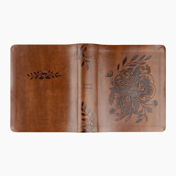 Brown leather notebook with floral embossing on a white background