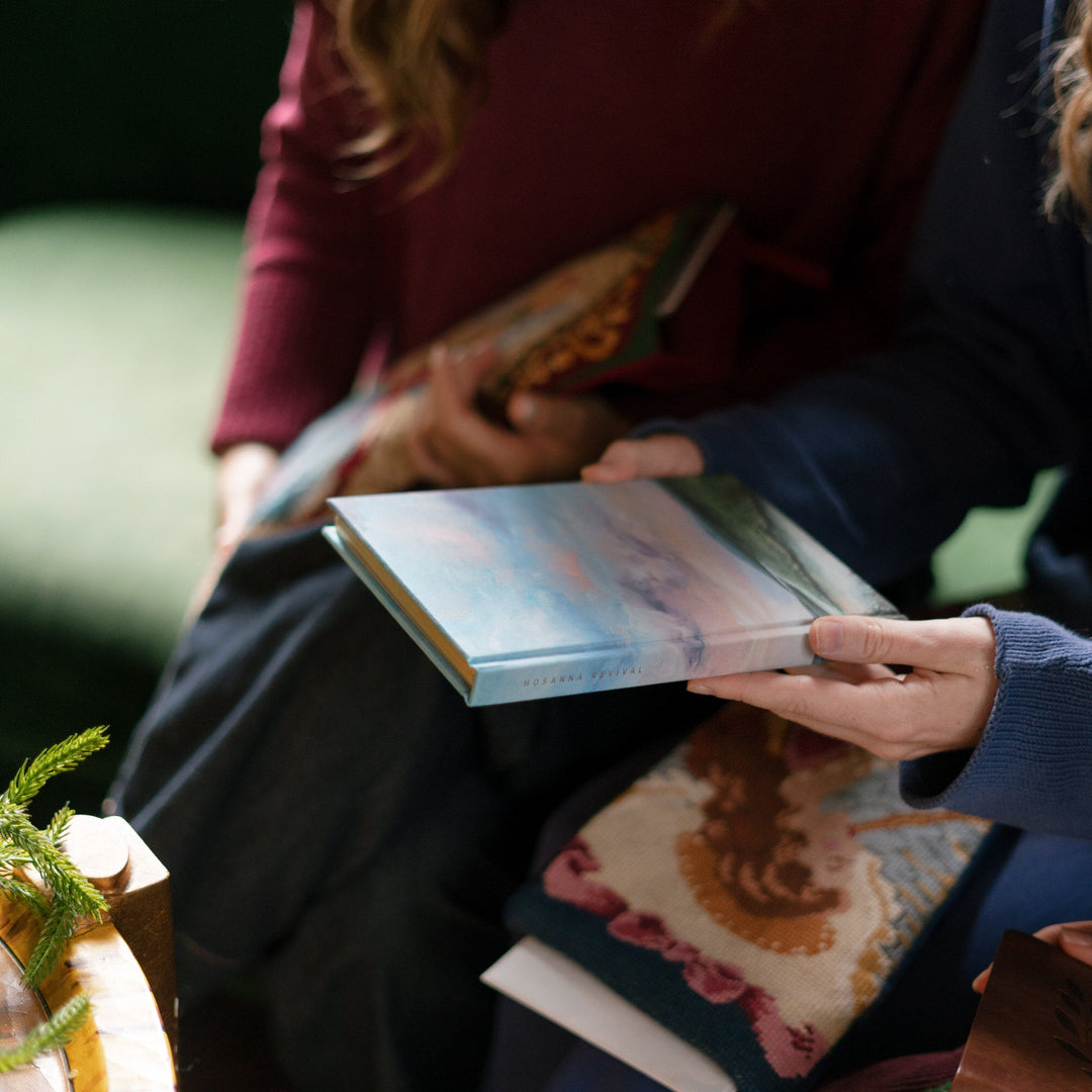 landscape journal in girl's hand near a christmas stocking