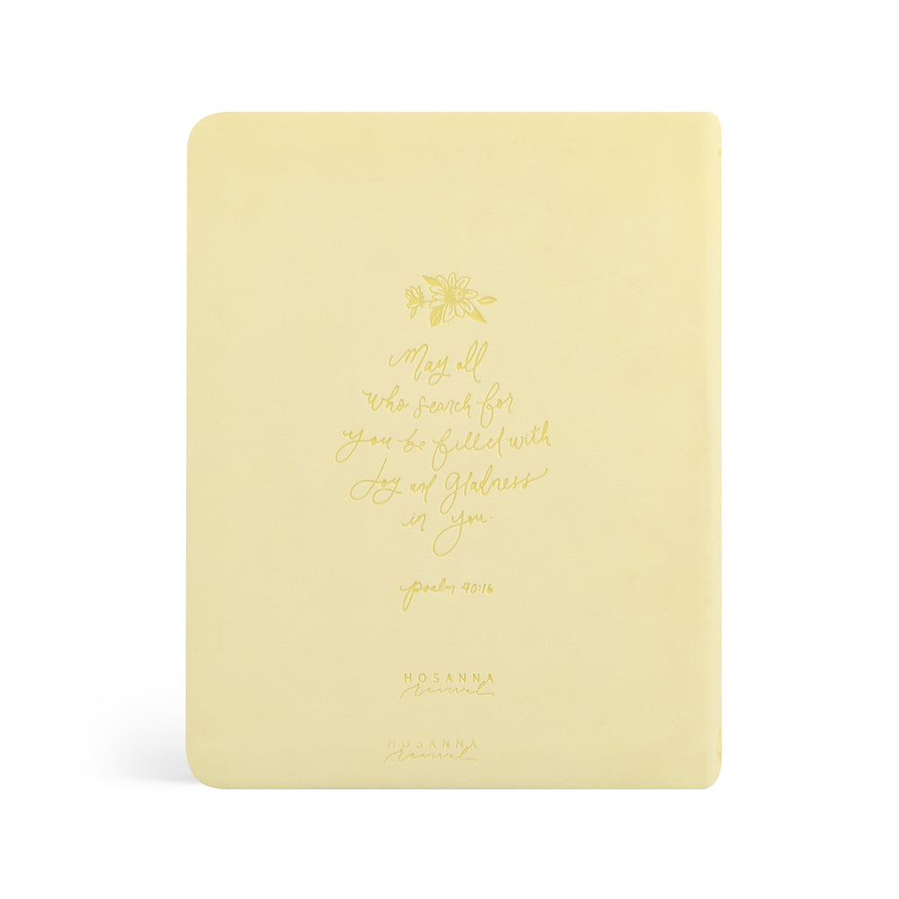 Yellow Bible with gold text and design on a white background
