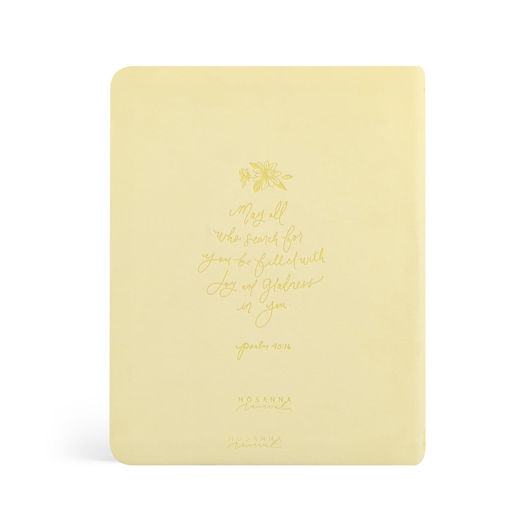 Yellow Bible with gold text and design on a white background