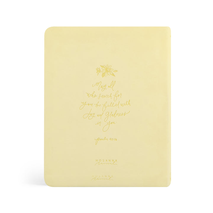 Yellow Bible with gold text and design on a white background