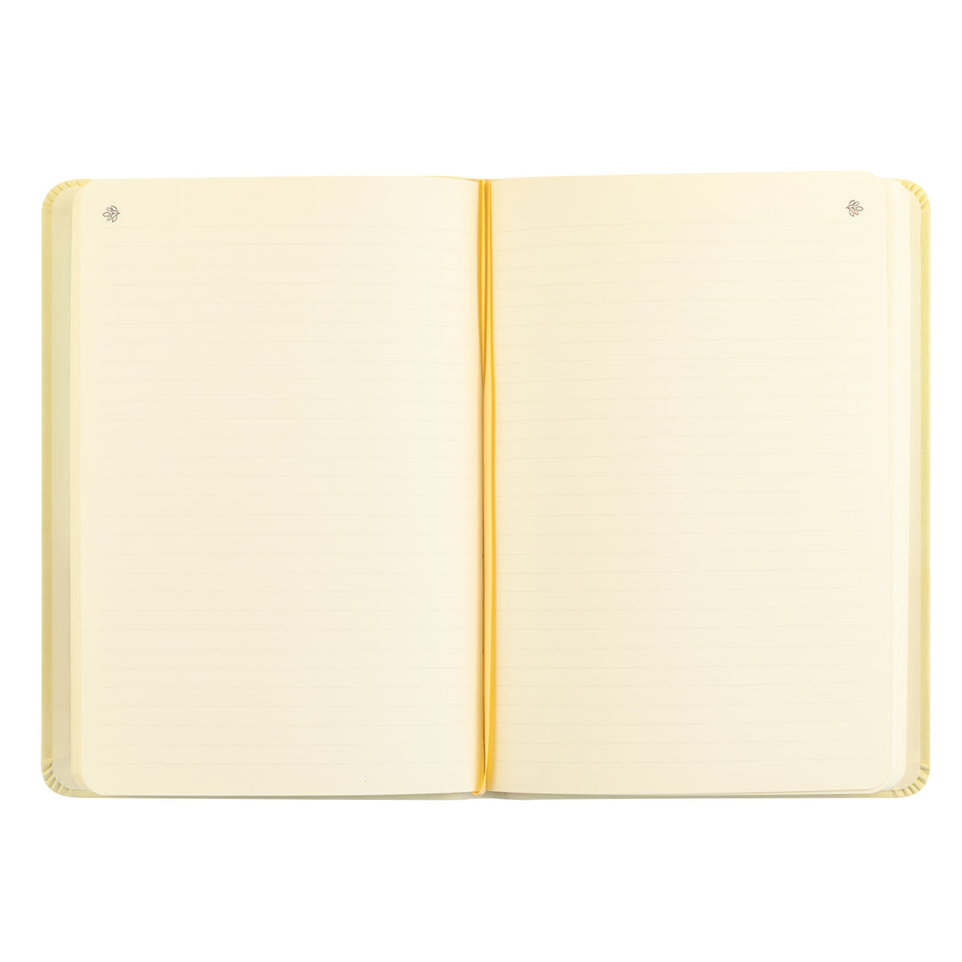 Open notebook with cream-colored pages and a gold binding on a white background