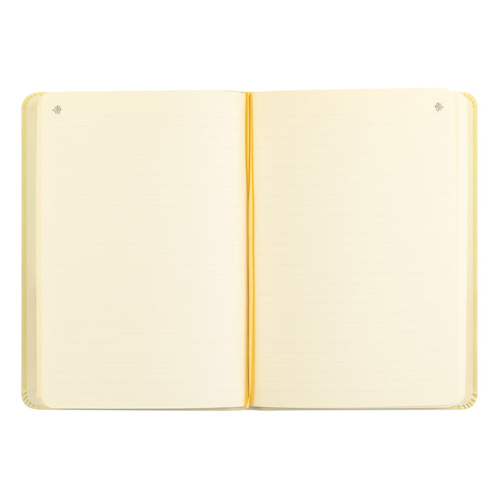 Open notebook with cream-colored pages and a gold binding on a white background