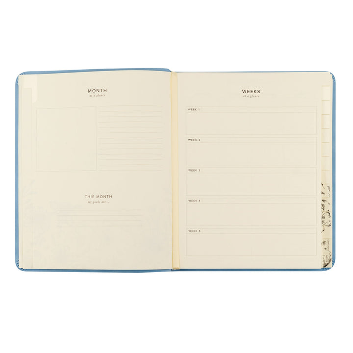 Open notebook with monthly and weekly planner layout on beige pages.