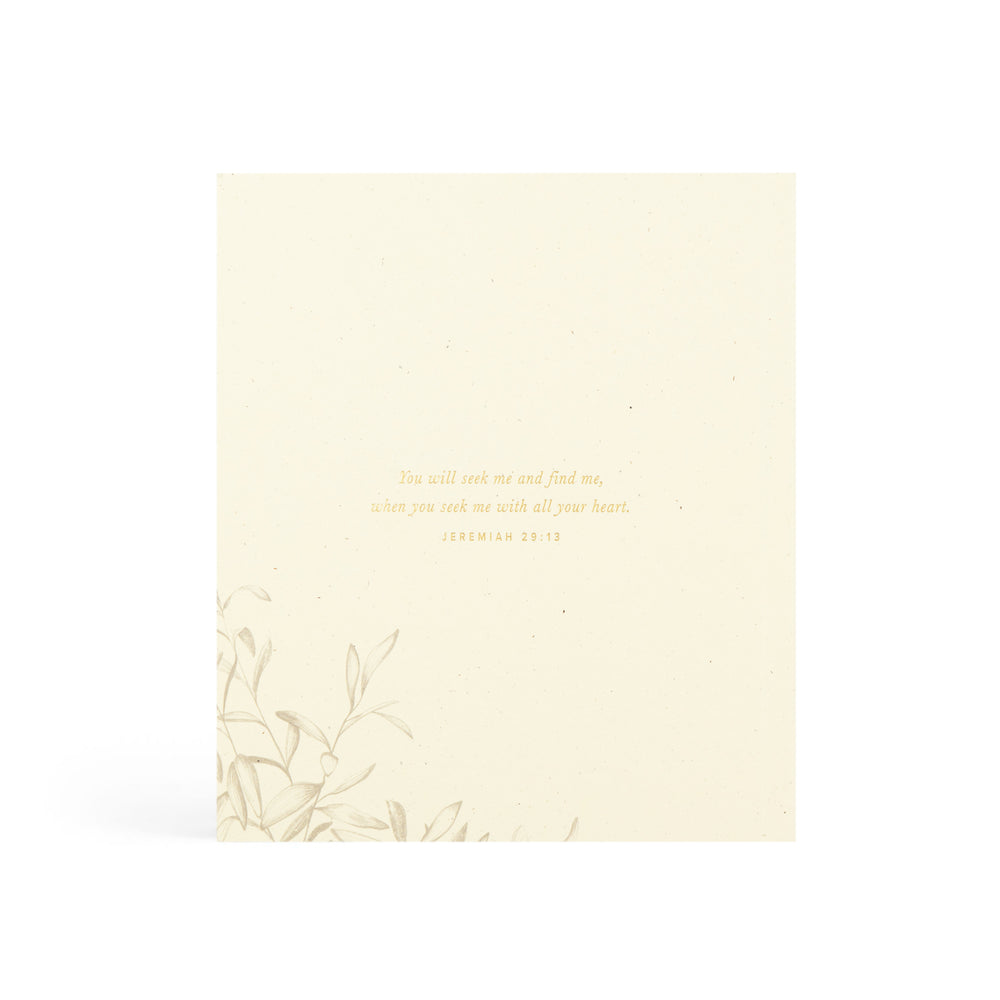 Beige booklet with gold text and leaf design on a white background