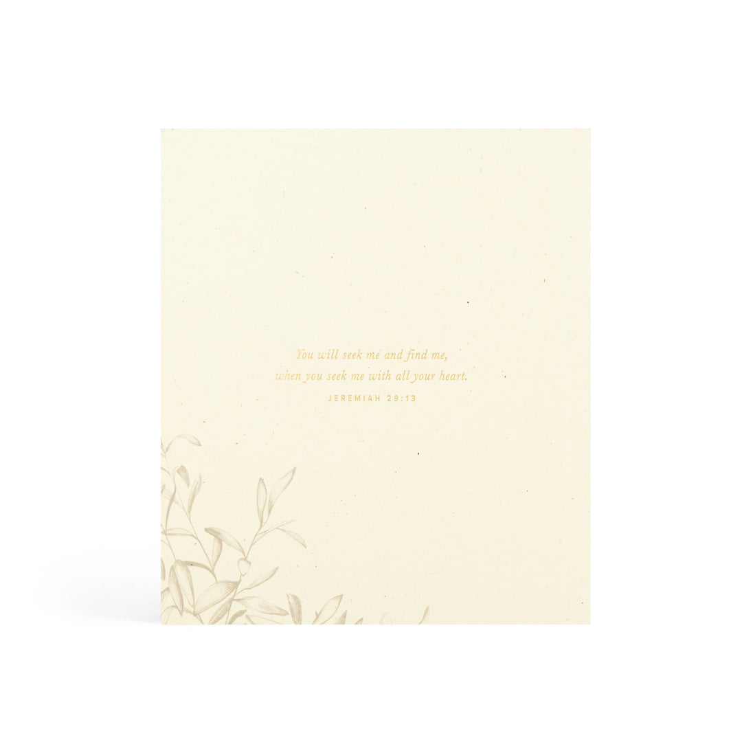 Beige booklet with gold text and leaf design on a white background