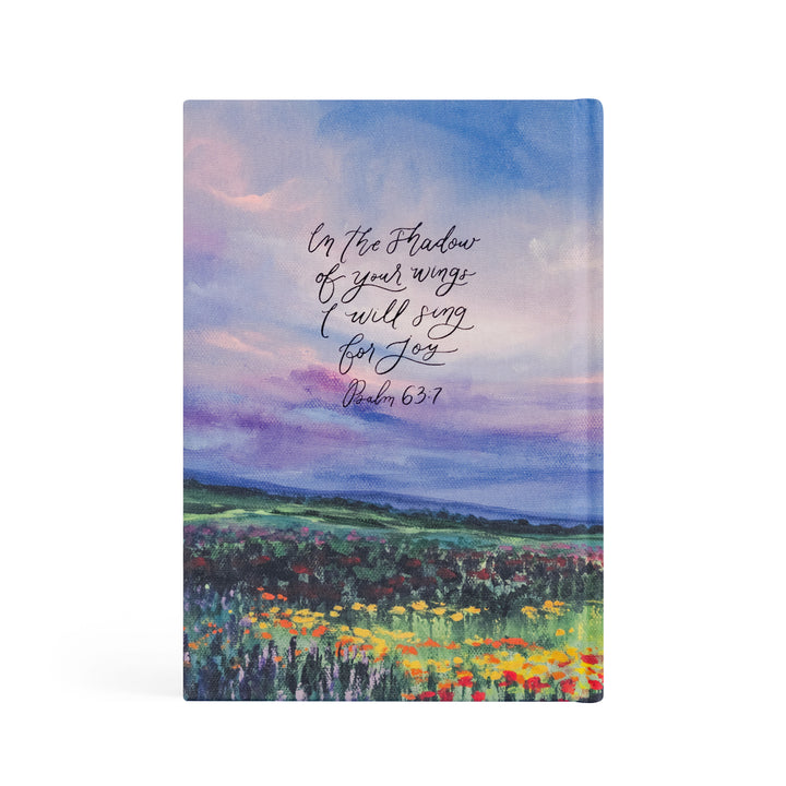 Notebook with a colorful landscape design and Bible verse text on the cover.