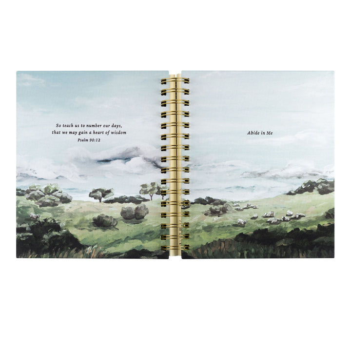 Open notebook with a scenic landscape illustration on the cover