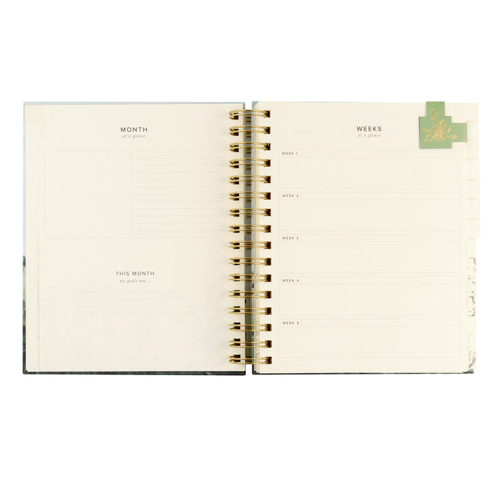 Open planner with monthly and weekly tabs on a white background