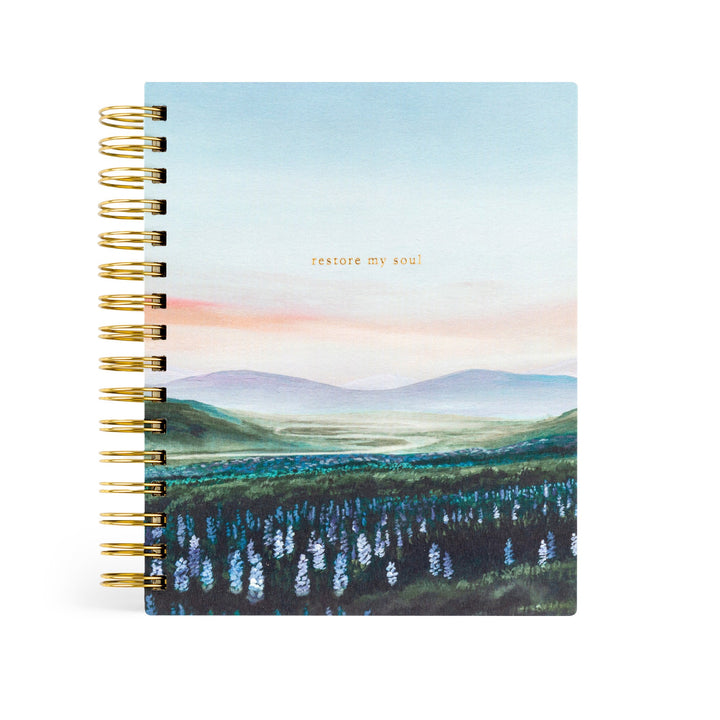 planner with a scenic cover design and gold spiral binding on a white background