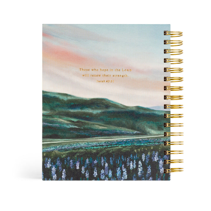 planner with a scenic cover design and gold spiral binding on a white background