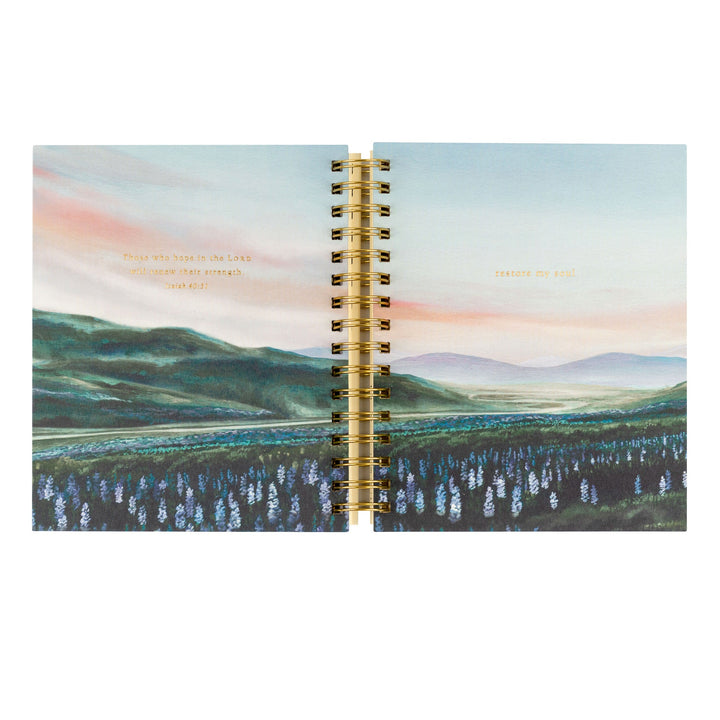 planner with a scenic cover design and gold spiral binding on a white background