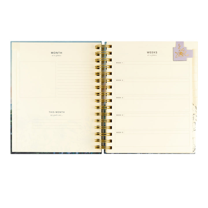 Open planner showing monthly and weekly tabs on a white background