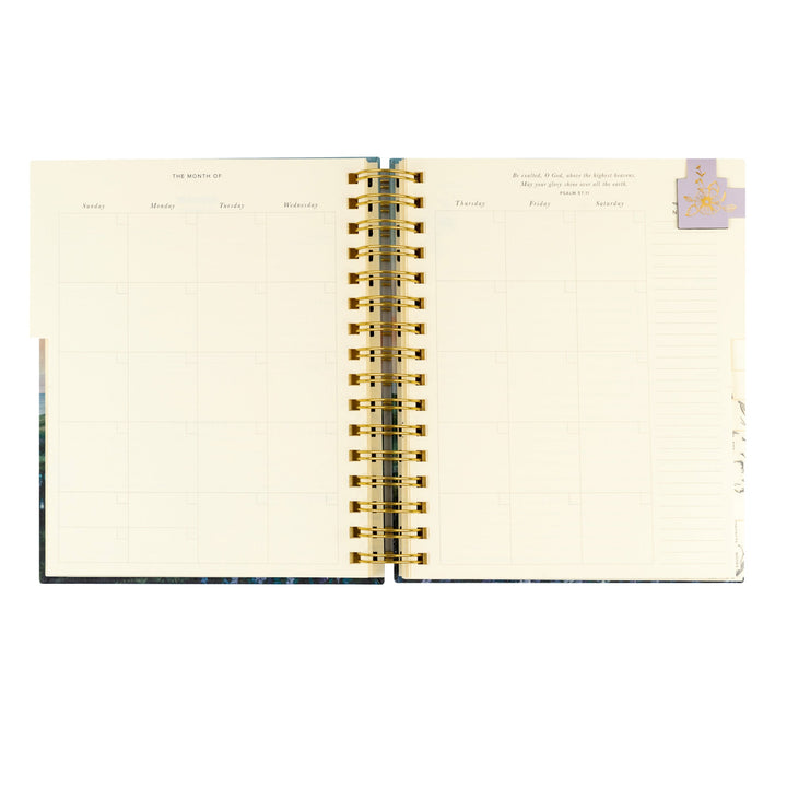 Open spiral-bound planner with gold binding on a white background