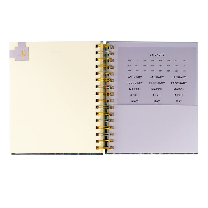 Spiral-bound planner with a calendar page and a blank page inside.