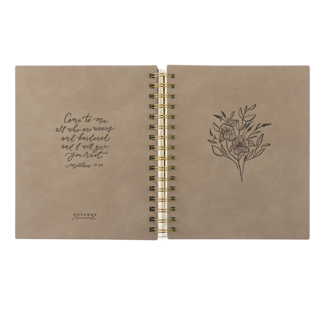 Open notebook with floral design and text on beige pages