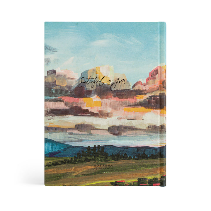 Bible with a colorful landscape cover on a white background