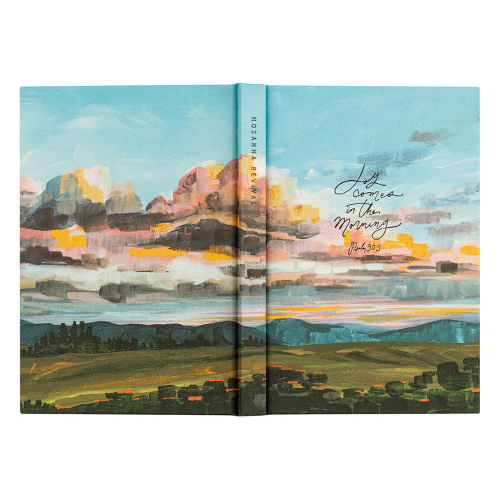 Open book with a colorful landscape illustration on a white background