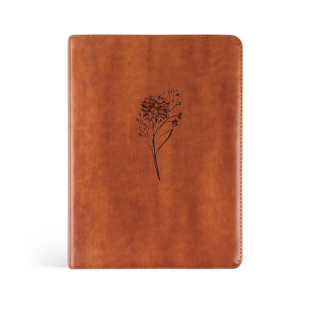 Brown leather notebook with a floral design on a white background