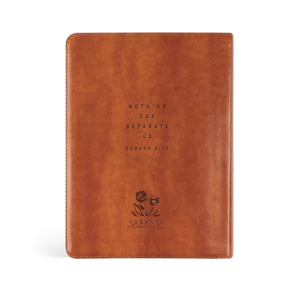 Brown leather notebook with embossed text and floral design on a white background