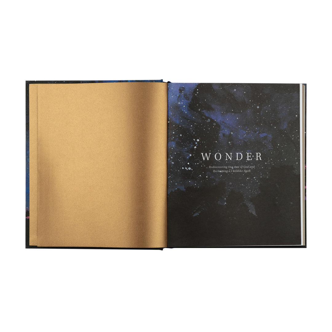 Open book with gold interior pages and a cover featuring a starry night design with the word 'Wonder'.