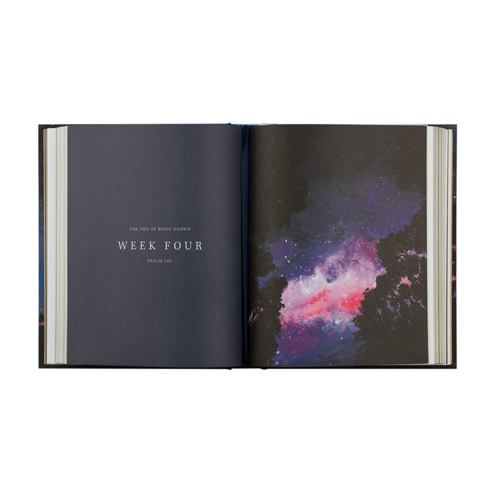 Open book showing a page with 'Week Four' text and another with a colorful nebula illustration.